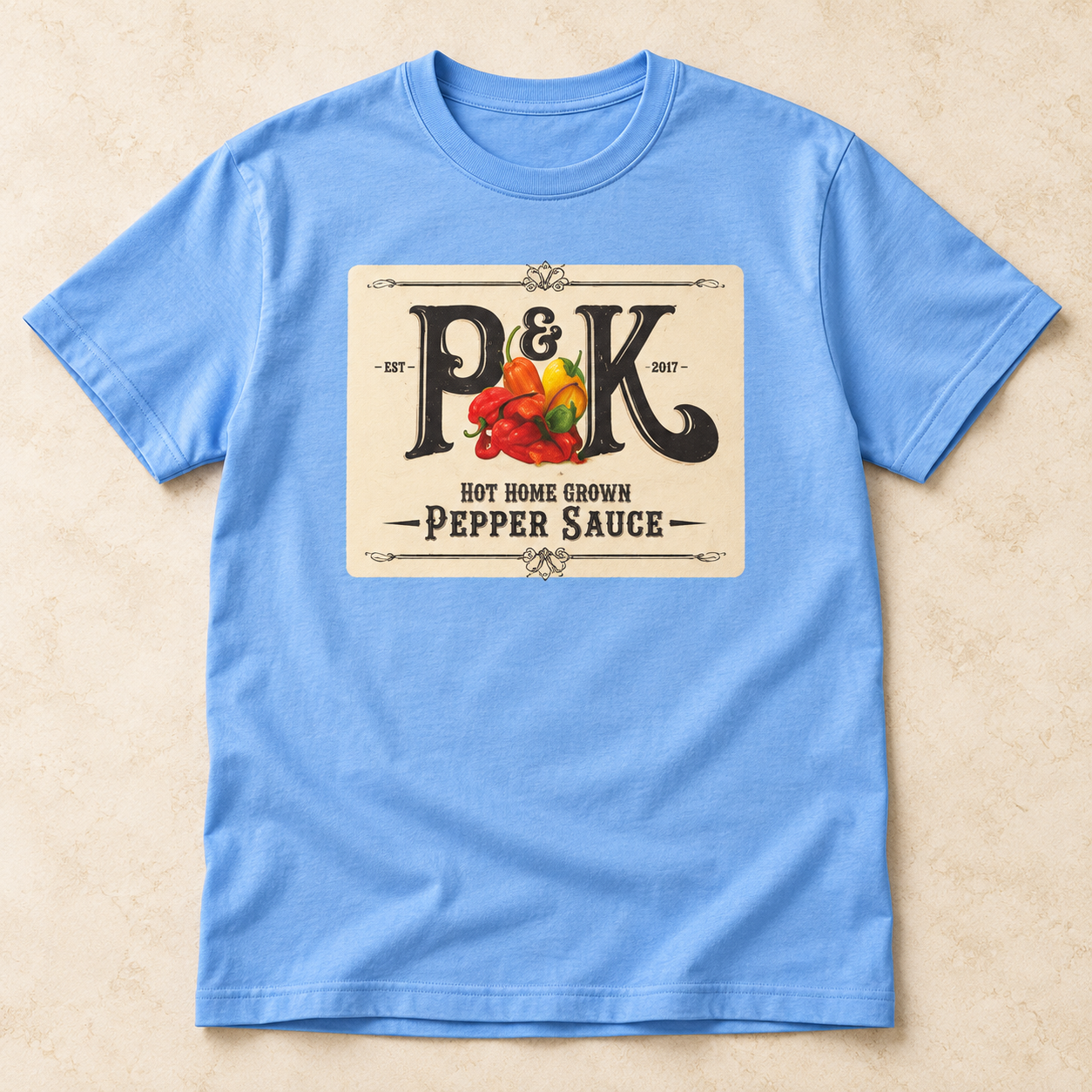 Light-blue P&K T-shirt concept with the cream Pepper Sauce print centered on the chest
